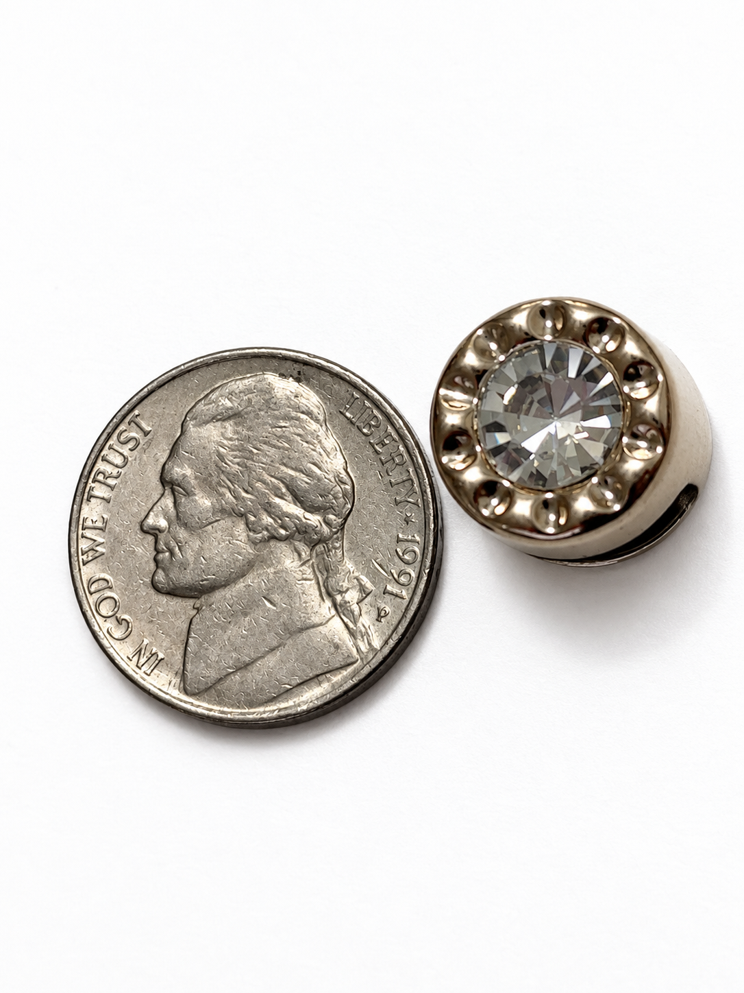 Gold solitaire crystal loc bead next to a US nickel showing its actual size