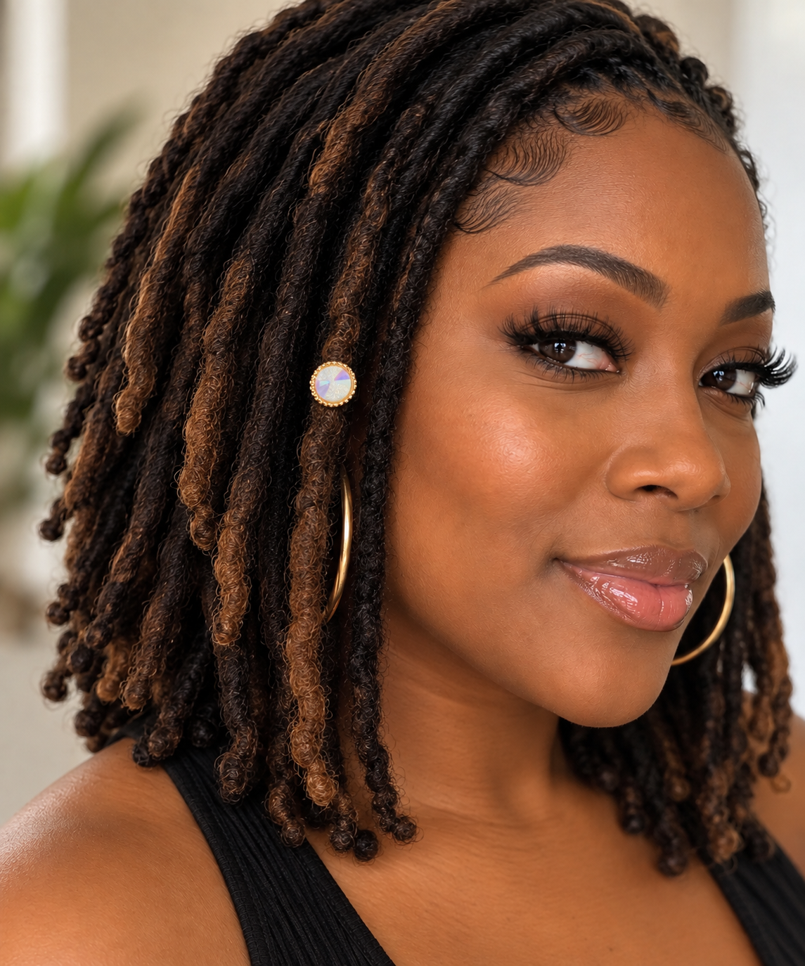 Woman wearing an iridescent crystal halo loc bead on her locs