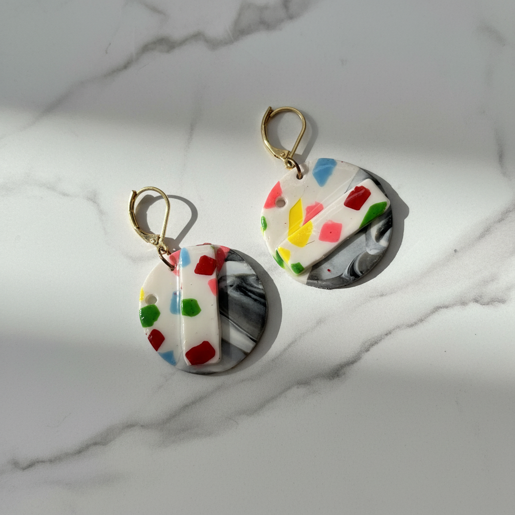 Gold beaded confetti dangle earrings on white marble surface